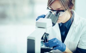Young scientist looking through a microscope in a laboratory - Sugar Land Mold Removal